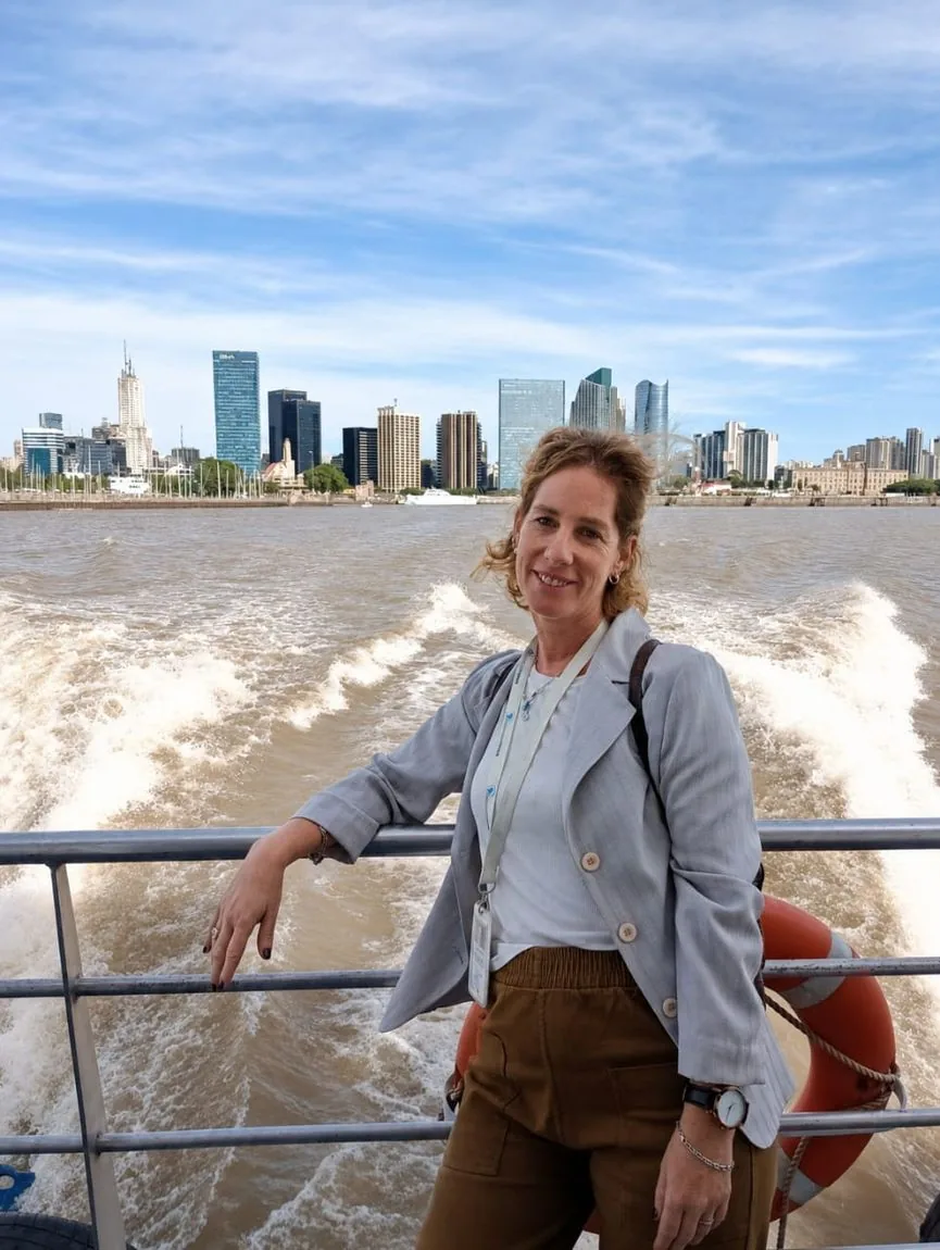 Débora on the river, with the Buenos Aires skyline behind her